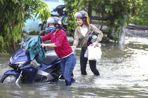 Người dân TP.HCM dắt xe sau mưa lớn