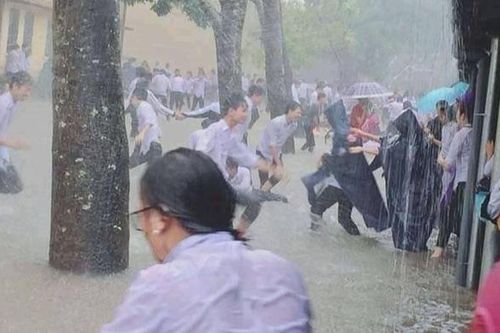 Bất chấp thời tiết bão bùng, nước mưa ngập đầu gối, các cô cậu học trò mặc sức vui đùa khiến nhiều người lo lắng