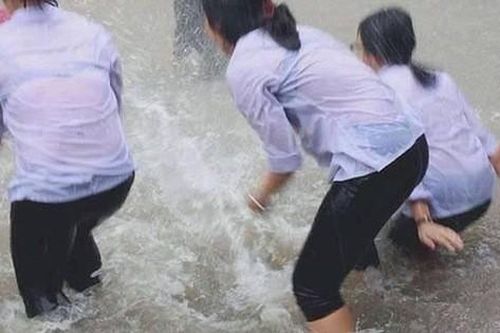 Mặc mưa ngập đến cả đầu gối, hàng chục học sinh vẫn vô tư chơi đùa dưới sân trường: Vui nhưng có an toàn?