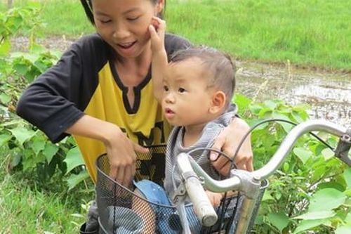 Xót thương cảnh bé gái 13 tuổi bế em 14 tháng tuổi đến trường