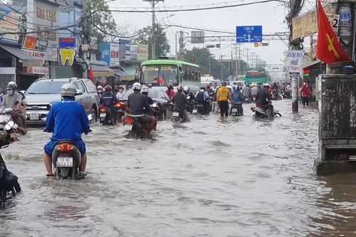 TPHCM: Triều cường dâng cao, người và phương tiện 'lội' nước