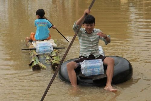 Tổ tình nguyện chia cơm nước, trẻ em dùng bè chuối đi nhận tiếp tế