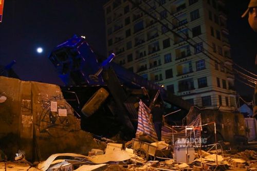Hà Nội: Xe cần cẩu bị lật làm đổ tường, 1 công nhân mắc kẹt dưới hố công trình