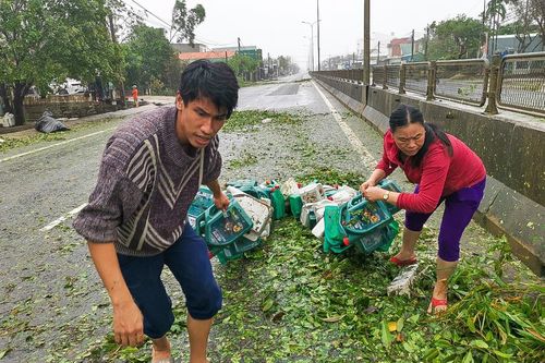 Người dân ra đường nhặt lại đồ dùng sau bão số 9