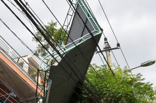 Mái tôn lơ lửng trên dây điện sau bão số 9
