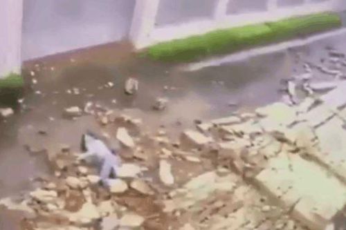 Clip: Đang đi trên đường, cô gái bất ngờ bị bức tường lớn đổ sập đè trúng người
