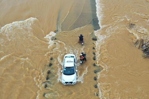 Băng qua cầu ngập trong dòng nước chảy xiết