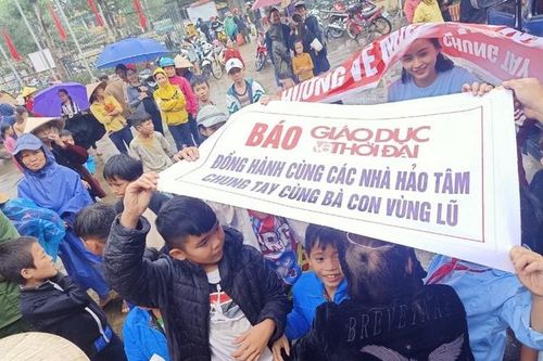 Bà con đội mưa nhận quà cứu trợ của bạn đọc Báo GD&TĐ