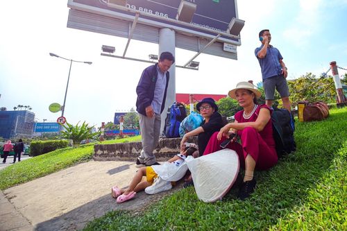Khách đội nắng ra đường đón xe công nghệ ở sân bay Tân Sơn Nhất