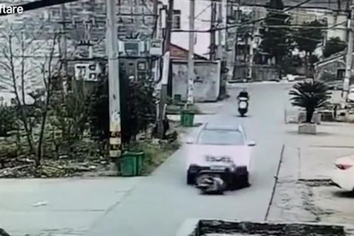 Bị cuốn vào gầm ô tô, tài xế xe máy may mắn thoát chết
