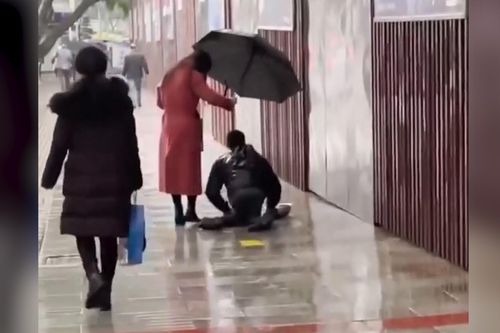 Xúc động cảnh cô gái cầm ô che cho người bị tật 2 chân dưới mưa