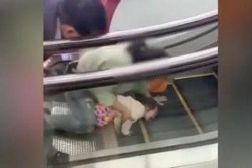 Bé gái khóc thét khi bị kẹt tay vào thang cuốn