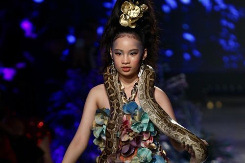 Mẫu nhí quấn trăn lên cổ trên sàn catwalk