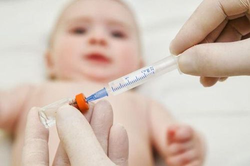 Xót xa hình ảnh bé gái 7 tuổi bế em đi tiêm phòng
