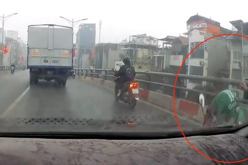 Trời mưa, xe máy bóp phanh ngã vào gầm ô tô