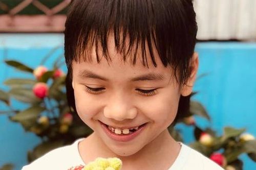 Em bé Mường Lát giờ đã lớn phổng phao, nở nụ cười hạnh phúc khi được mẹ nuôi tặng quà ngày cận Tết