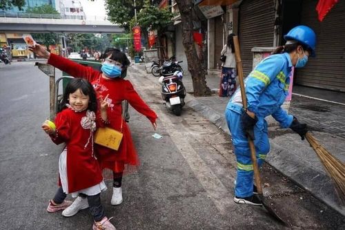 Hai bé mặc áo dài đỏ, theo mẹ làm lao công sáng mùng 1 Tết
