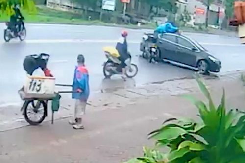 Nam thanh niên đi xe máy bay thẳng lên nóc ô tô đang lùi xuống đường