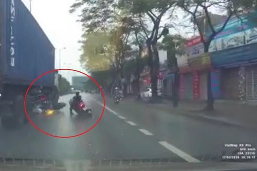 Hai xe máy chui gầm container thoát chết ngoạn mục