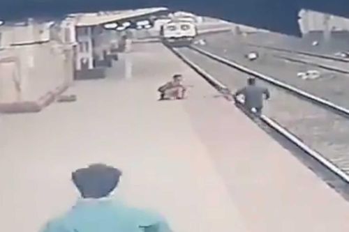 Giải cứu em bé trước mũi tàu hỏa trong gang tấc