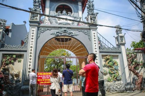 Hà Nội: Đền chùa đóng cửa, người dân hành lễ, thắp hương, vái vọng trước cổng chùa
