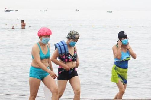 Đà Nẵng gỡ lệnh cấm, người dân bịt kín khẩu trang tắm biển từ tinh mơ
