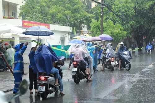 Hà Nội: Phụ huynh đội mưa đưa con đi thi, phải về lấy quần áo gửi đến phòng thi cho con thay