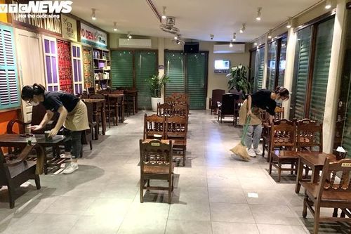Chủ quán Hà Nội buồn bã thu dọn đồ trước giờ dừng hoạt động để chống COVID-19