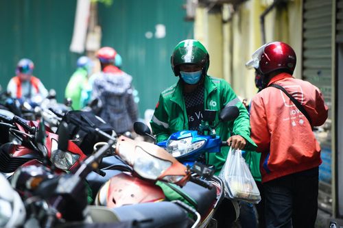 Ứng dụng và shipper hối hả làm thẻ tên, băng tay