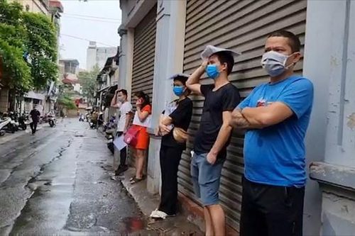 Người dân vẫn đội mưa xếp hàng chờ xác nhận giấy đi đường trước khi có thông báo mới của thành phố