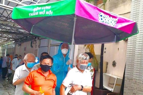 Chàng trai che mưa cho người lớn tuổi ở điểm tiêm vaccine tại TP.HCM