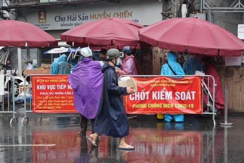 Người dân đội mưa đợi gửi lương thực, nhu yếu phẩm trong khu cách ly