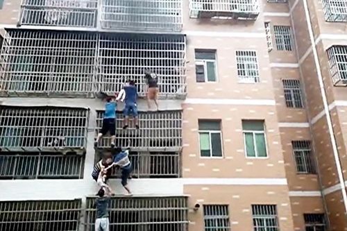 Người dân hợp sức giải cứu 2 bé gái thoát khỏi căn hộ đang bốc cháy