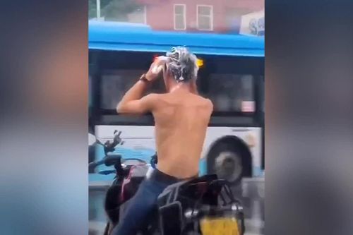 Người đàn ông gội đầu khi đang đi xe máy ở Trung Quốc