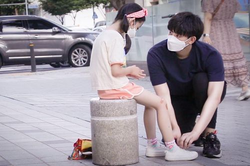 Bé gái bị ngã được người lạ giúp buộc dây giày ở Hàn Quốc
