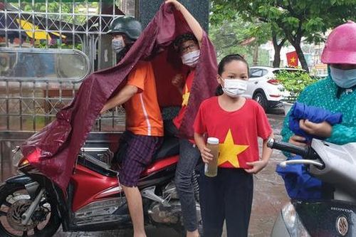 Học sinh đội mưa, đeo kính chắn giọt bắn dự lễ khai giảng