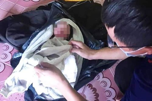 Bé gái sơ sinh nằm cạnh thùng rác