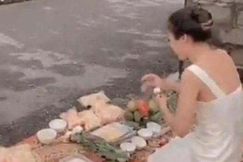Người phụ nữ trẻ mang vàng, hương đến trước nhà 'con nợ' cúng bái