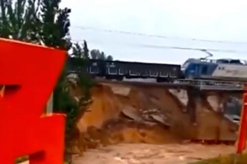 Nước lũ cuốn trôi chân cầu khiến đoàn tàu treo lơ lửng trên đường ray