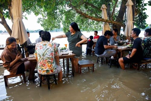 Thực khách thưởng thức đồ ăn giữa dòng nước ngập ở Thái Lan