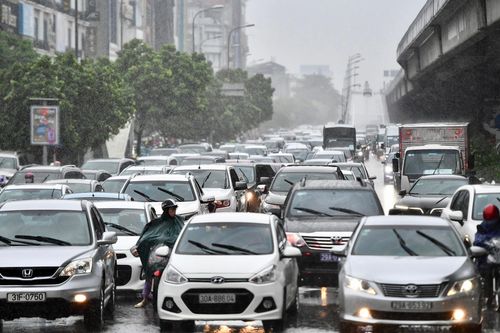 Người đi đường chật vật trong trận mưa sáng đầu tuần