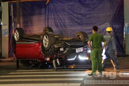 TPHCM: Ôtô húc văng trụ đèn rồi lật ngửa, 2 người bò ra ngoài kêu cứu