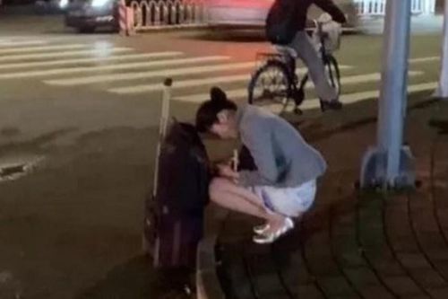 Nữ tiếp viên hàng không mặc váy ngắn, ngồi co ro bên lề đường dưới trời 0 độ C