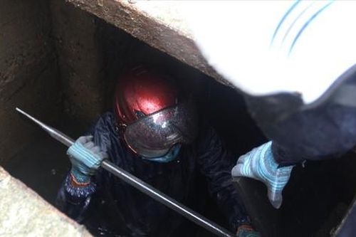 Nhọc nhằn nghề thông cống ngầm trong mưa