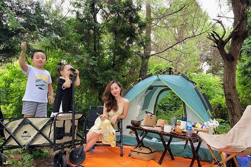 Vợ chồng trẻ chăm cho con đi cắm trại để tận hưởng cuộc sống