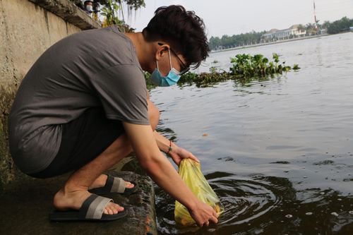 Sợ cá phóng sinh bị bắt lại, người dân thuê ghe ra giữa sông Sài Gòn 'tiễn ông Táo'