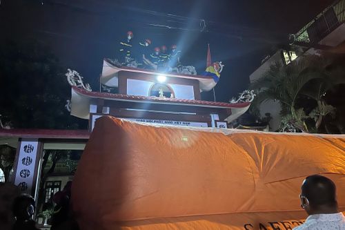 Giải cứu người phụ nữ leo tít lên cổng chùa múa gậy