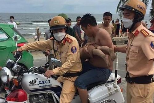 Xe cảnh sát hú còi đưa bé trai đuối nước trên biển đi cấp cứu