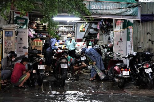 Tiệm sửa xe ở khu Thảo Điền đông nghẹt người sau trận ngập