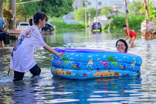 Trẻ em mang phao ra giữa phố để... tắm biển